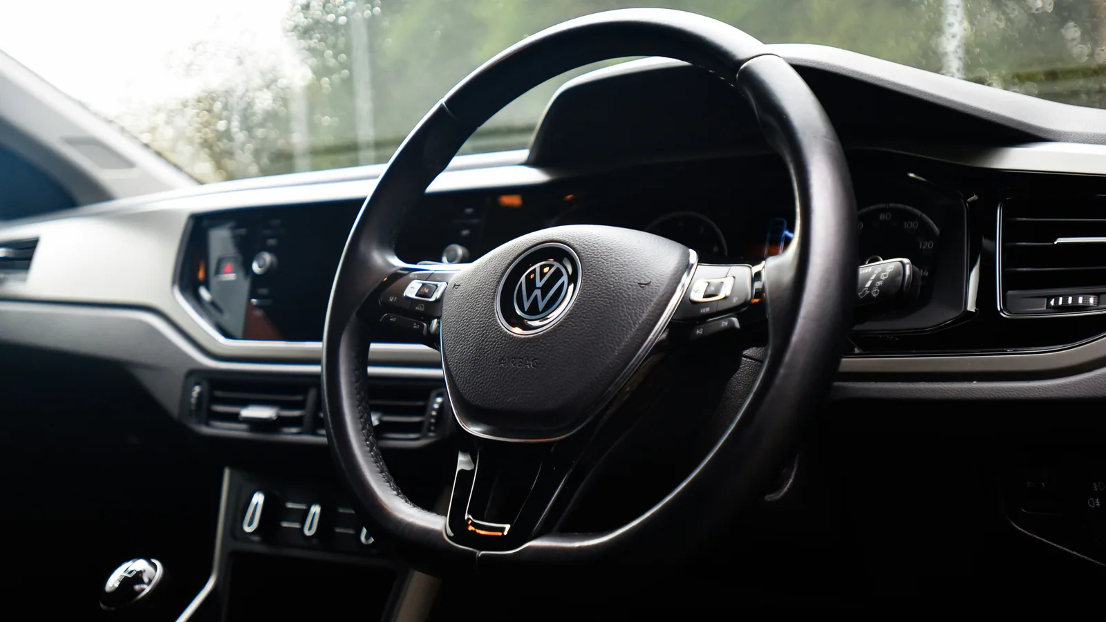 A Volkswagen steering wheel and dashboard in natural light.